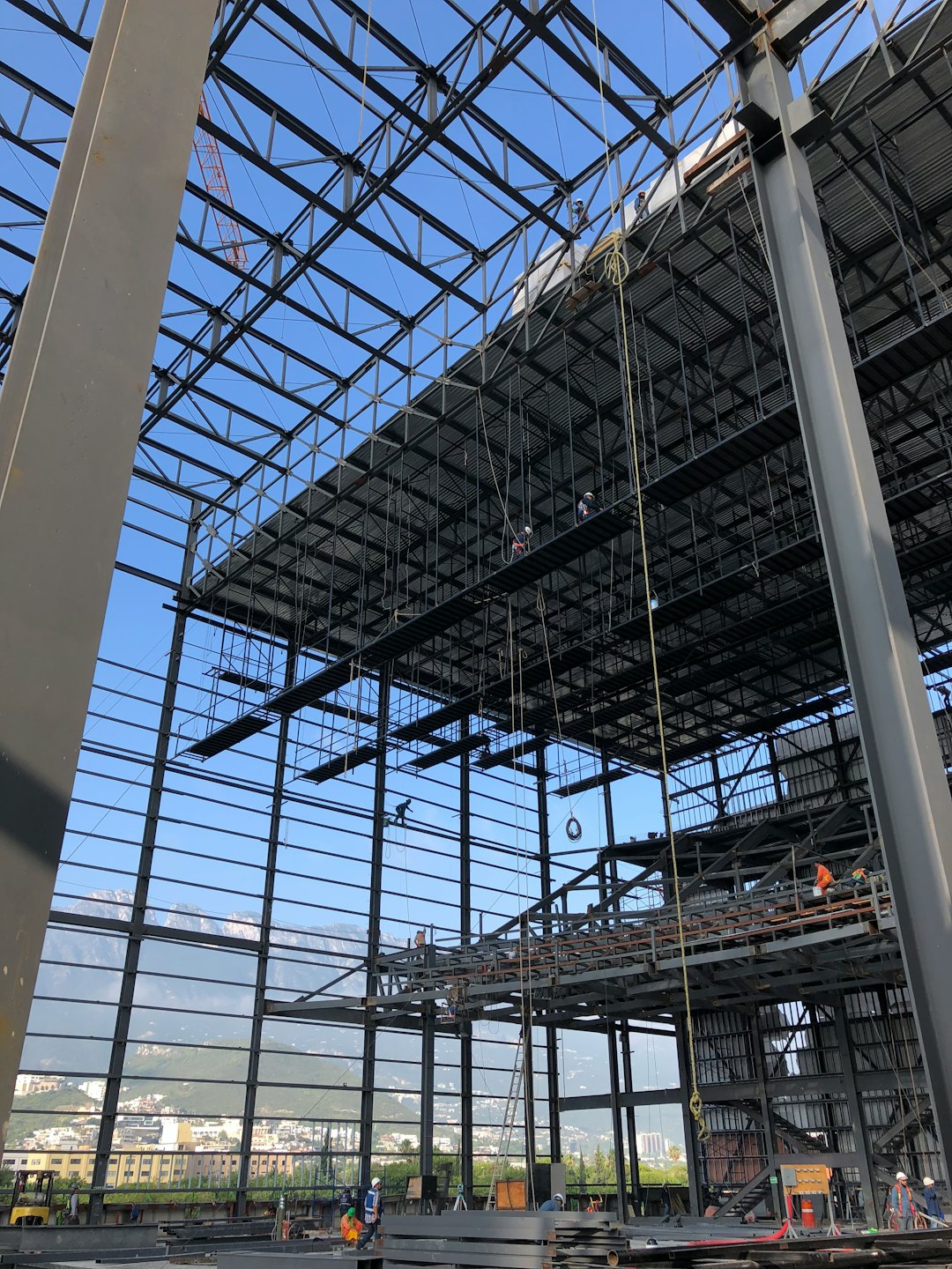 Trabajadores de la construcción instalando vigas de acero en un edificio grande.