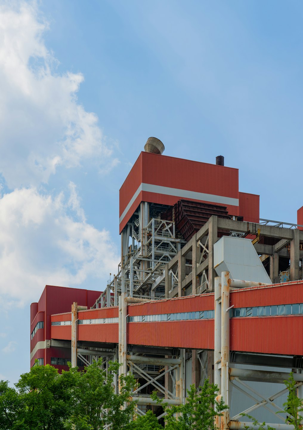 Gran complejo industrial con edificios de metal rojo y tuberías metálicas.